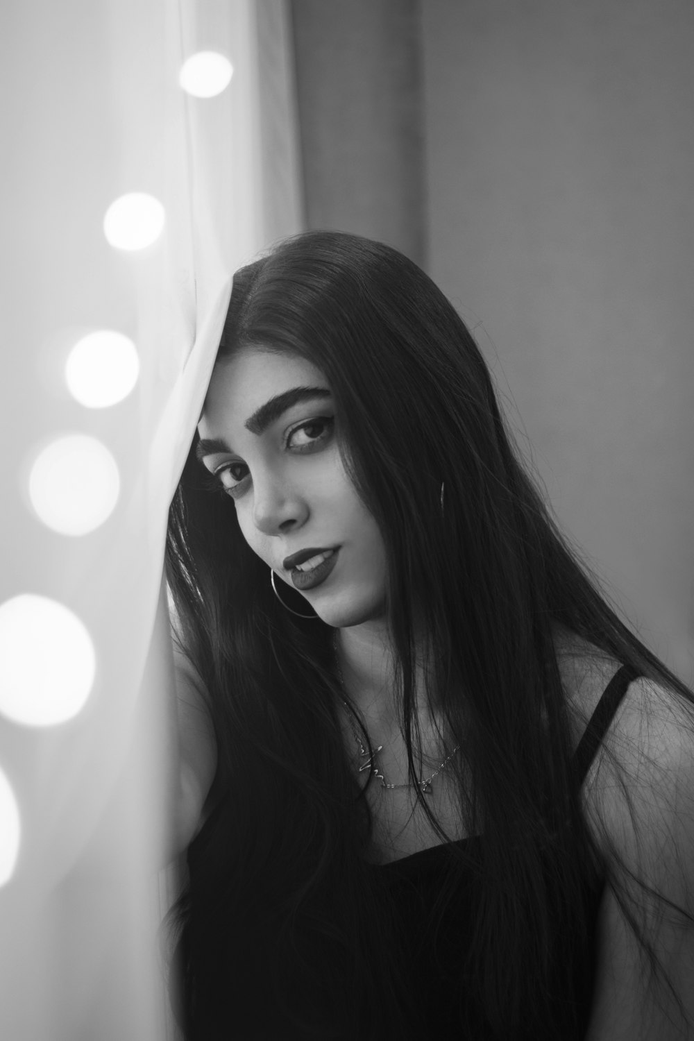 a woman with long hair looking out of a window