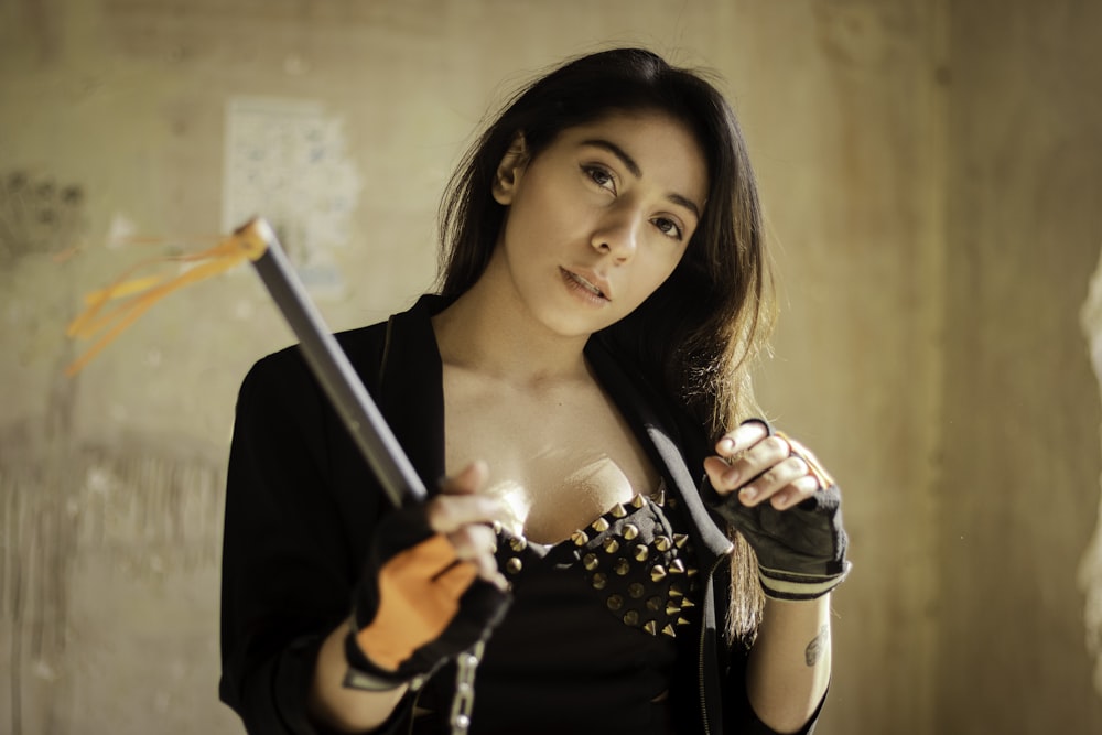 a woman in a black top holding a sword