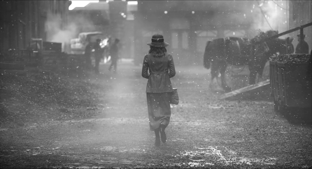 a woman walking down a street in the rain