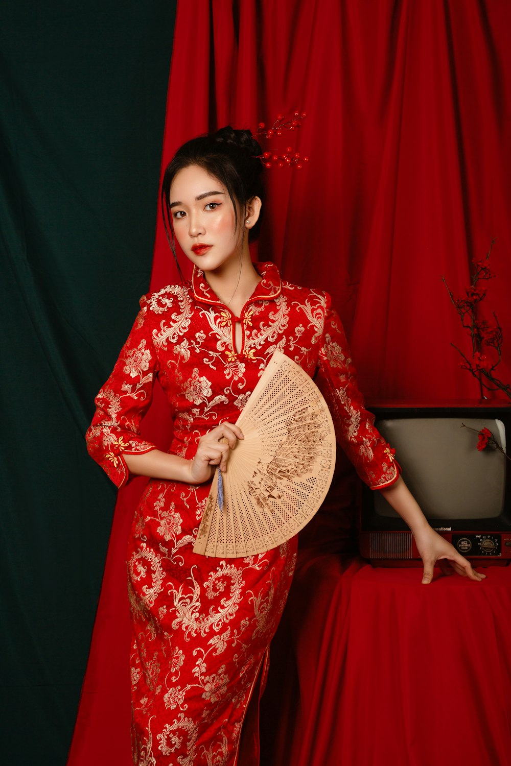 a woman in a red dress holding a fan