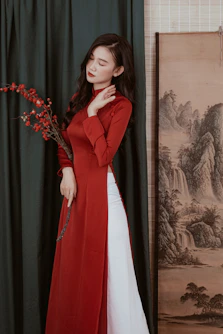 a woman in a long red coat and white dress