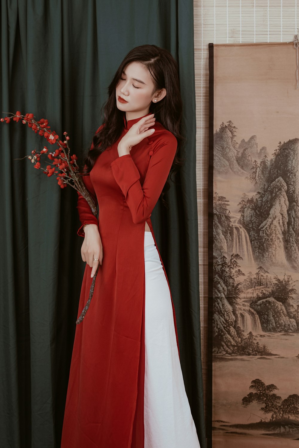 Una mujer con un largo abrigo rojo y vestido blanco