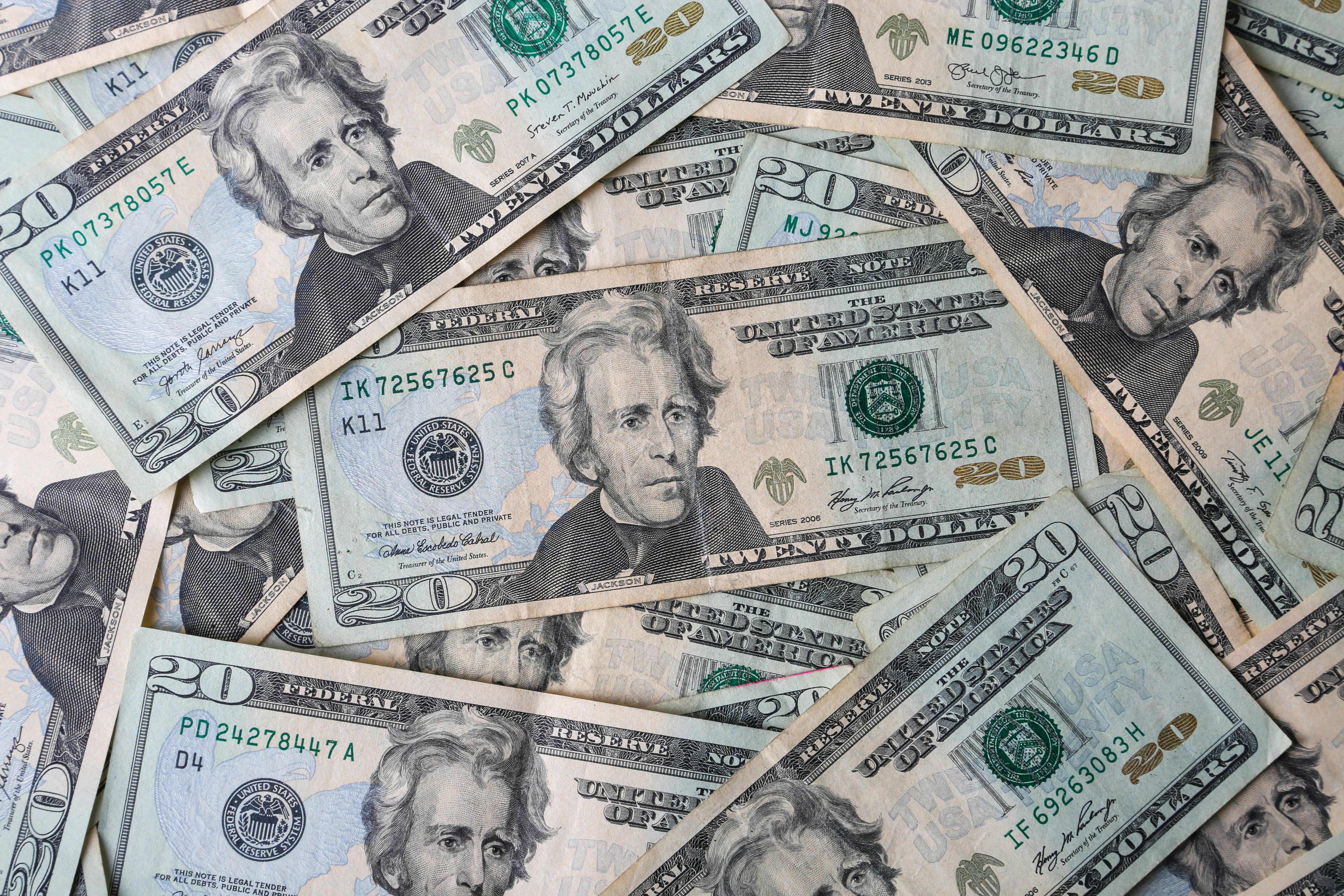 a pile of twenty dollar bills laying on top of each other