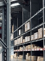 Shelves filled with organized car components in a spacious warehouse.