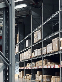 A modern warehouse with neatly stacked FMCG goods illuminated by ambient galaxy-inspired lighting.
