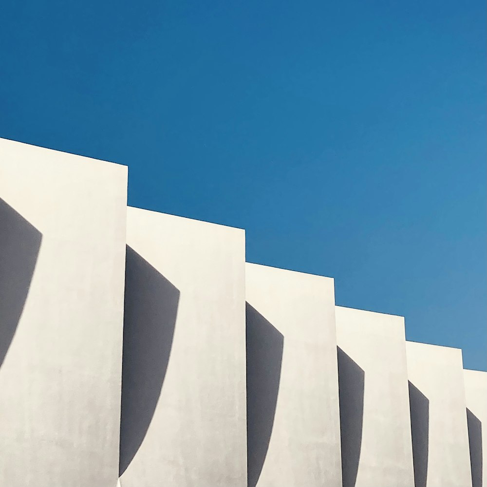 a row of white walls with a blue sky in the background