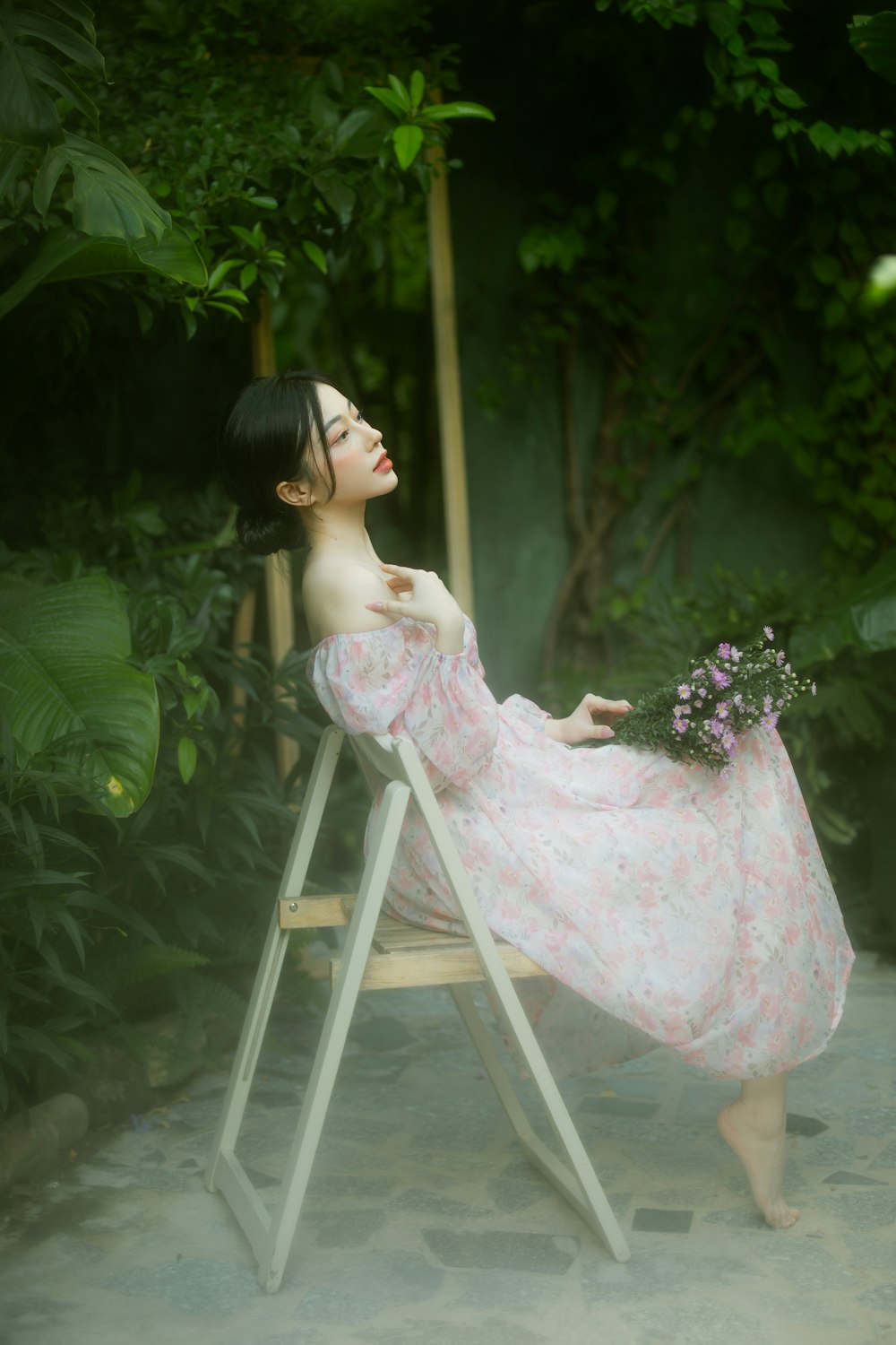 a woman in a pink dress sitting on a chair