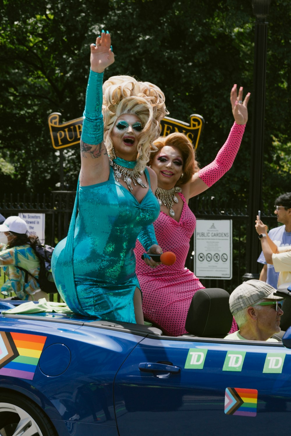 a couple of women riding in the back of a blue car