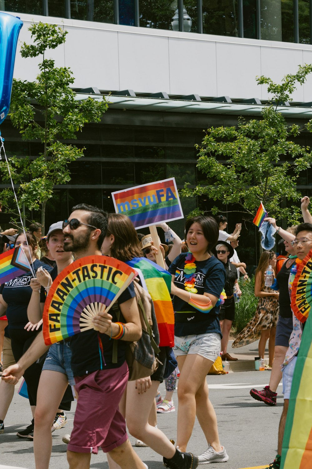 a group of people walking down a street holding rainbow flags