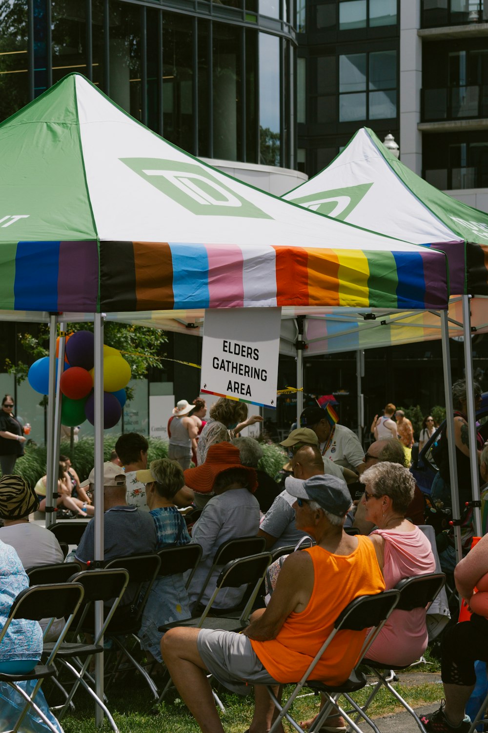 a group of people sitting under a colorful tent