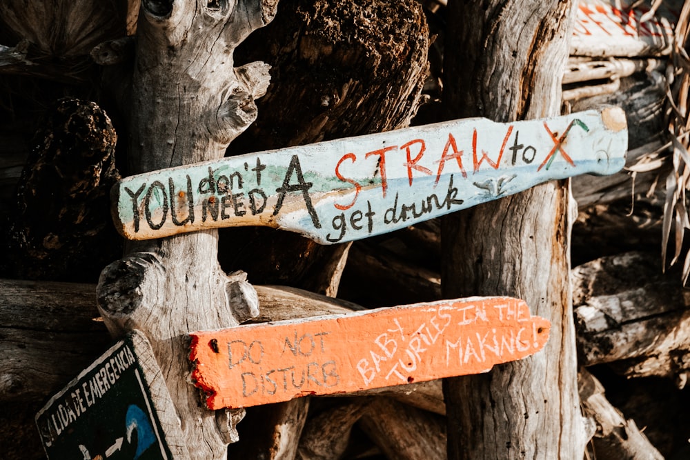 a close up of a wooden sign with graffiti on it