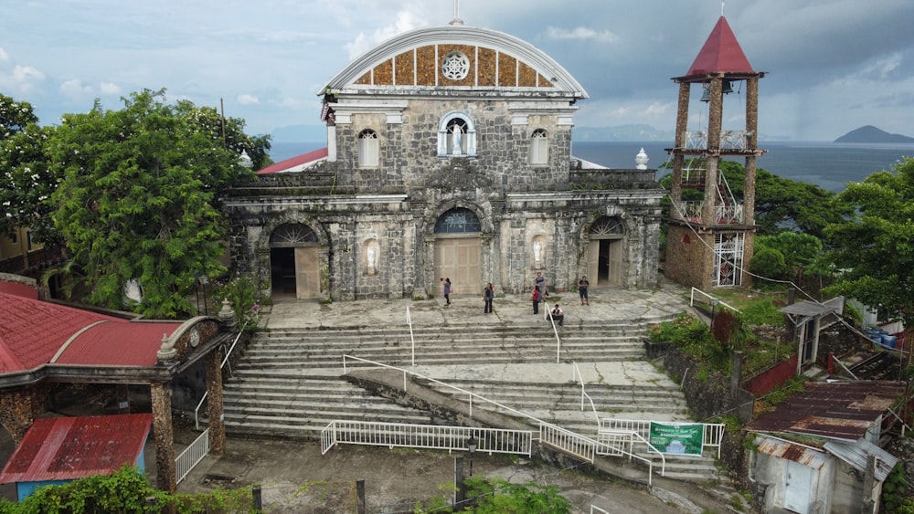 an old church with a steeple next to a body of water