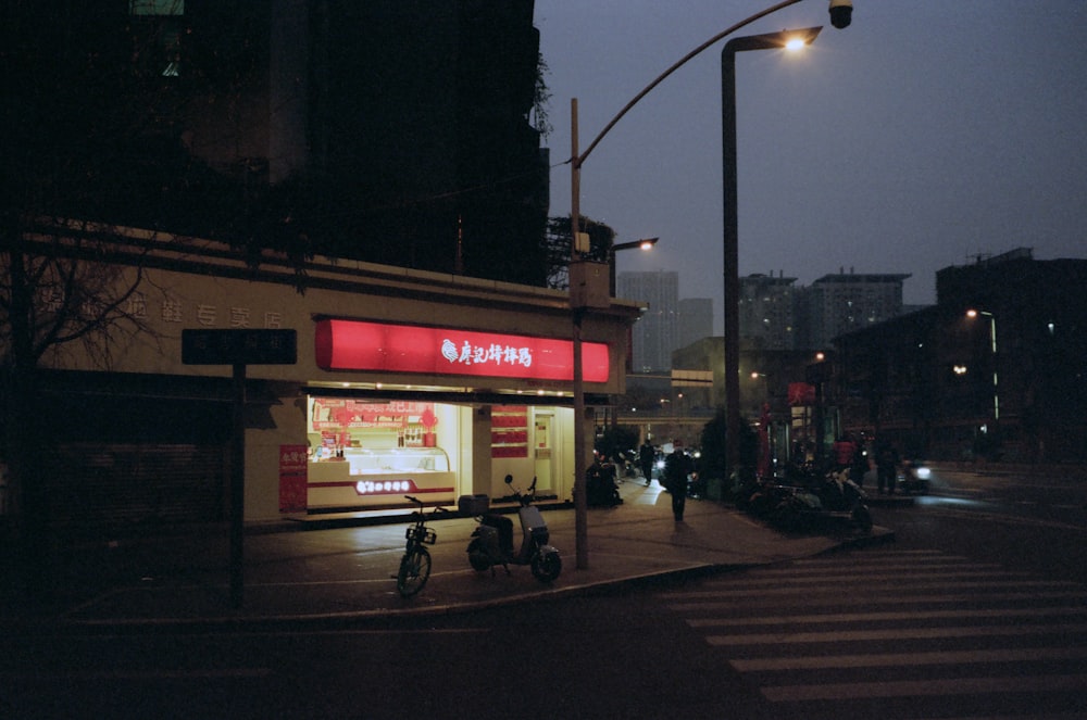 a city street at night with a chinese restaurant on the corner