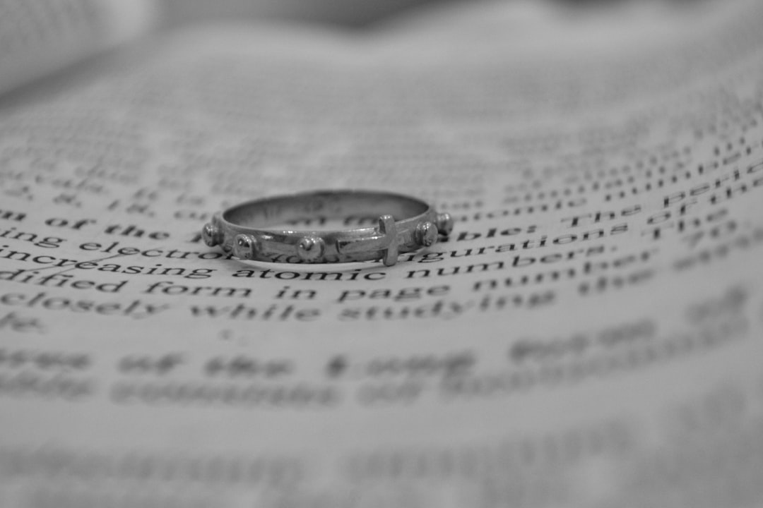 Single-decade rosary ring laying on bible page