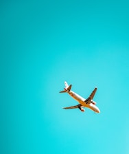 A friendly customer service agent speaking on the phone with an airplane flying in the background.