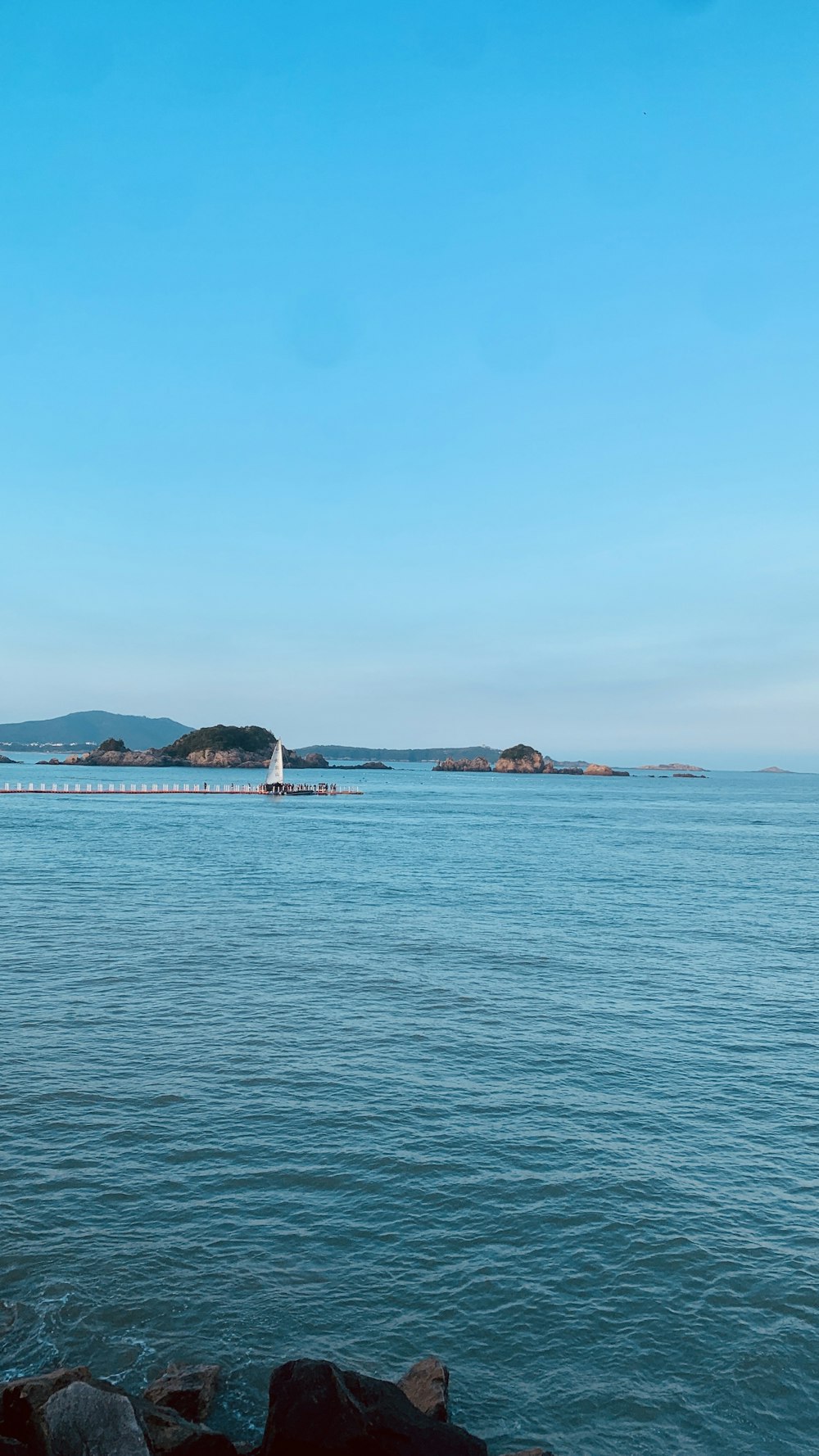 a large body of water with a light house in the distance