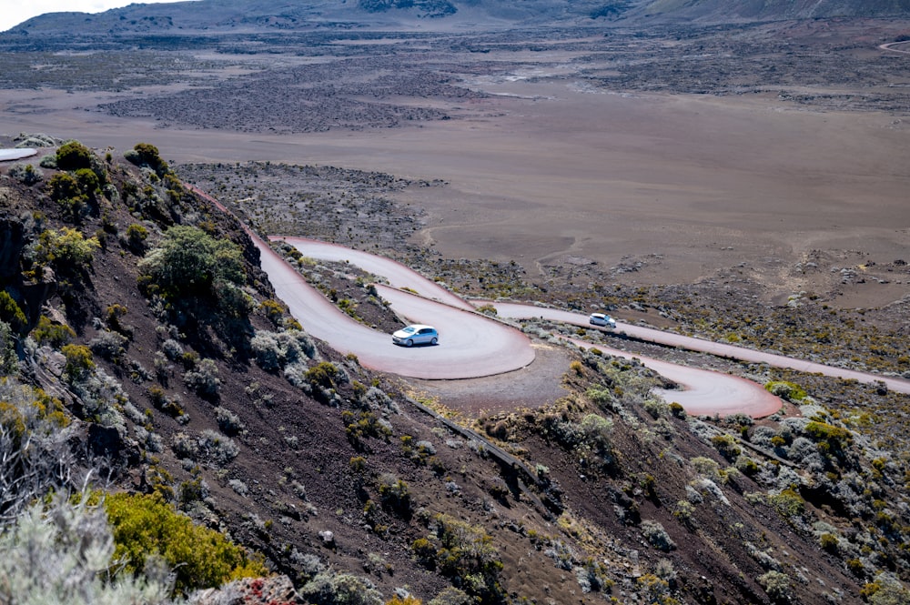 a car driving down a winding road in the mountains