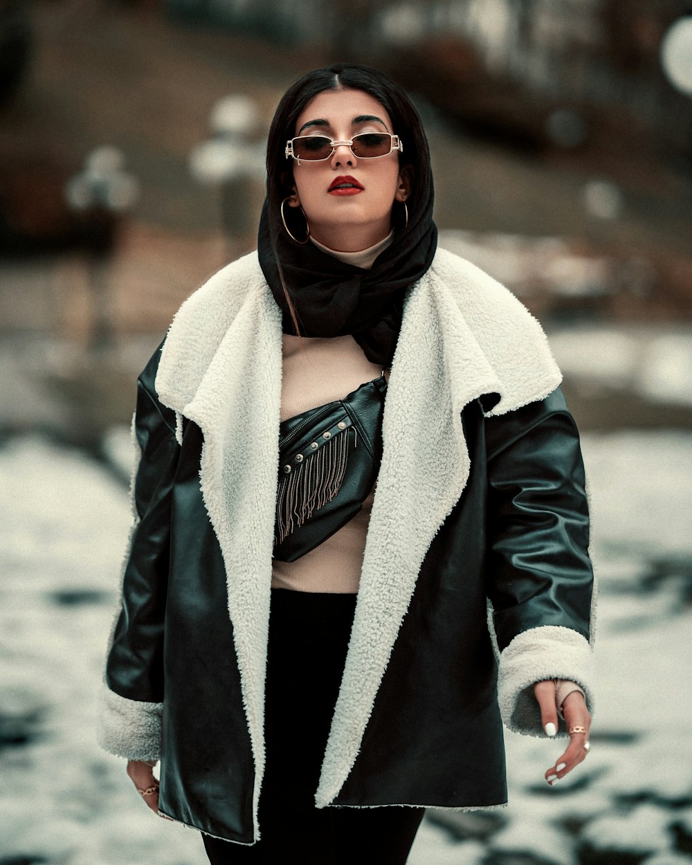a woman in a black leather jacket and white fur coat