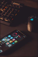 Top-down shot of a gaming phone surrounded by neon cables and tech gadgets in dark mode.