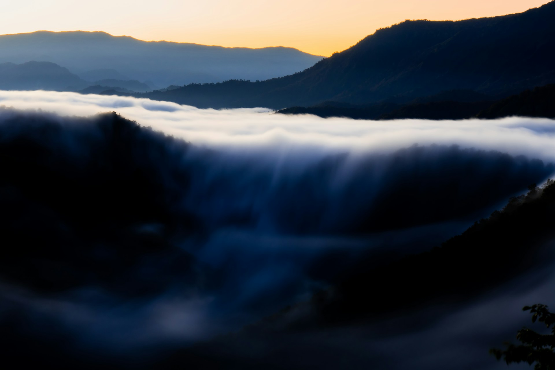 a view of a mountain range covered in clouds