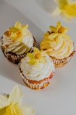 Delicate cupcakes with swirls of chocolate and vanilla frosting, topped with edible flowers.