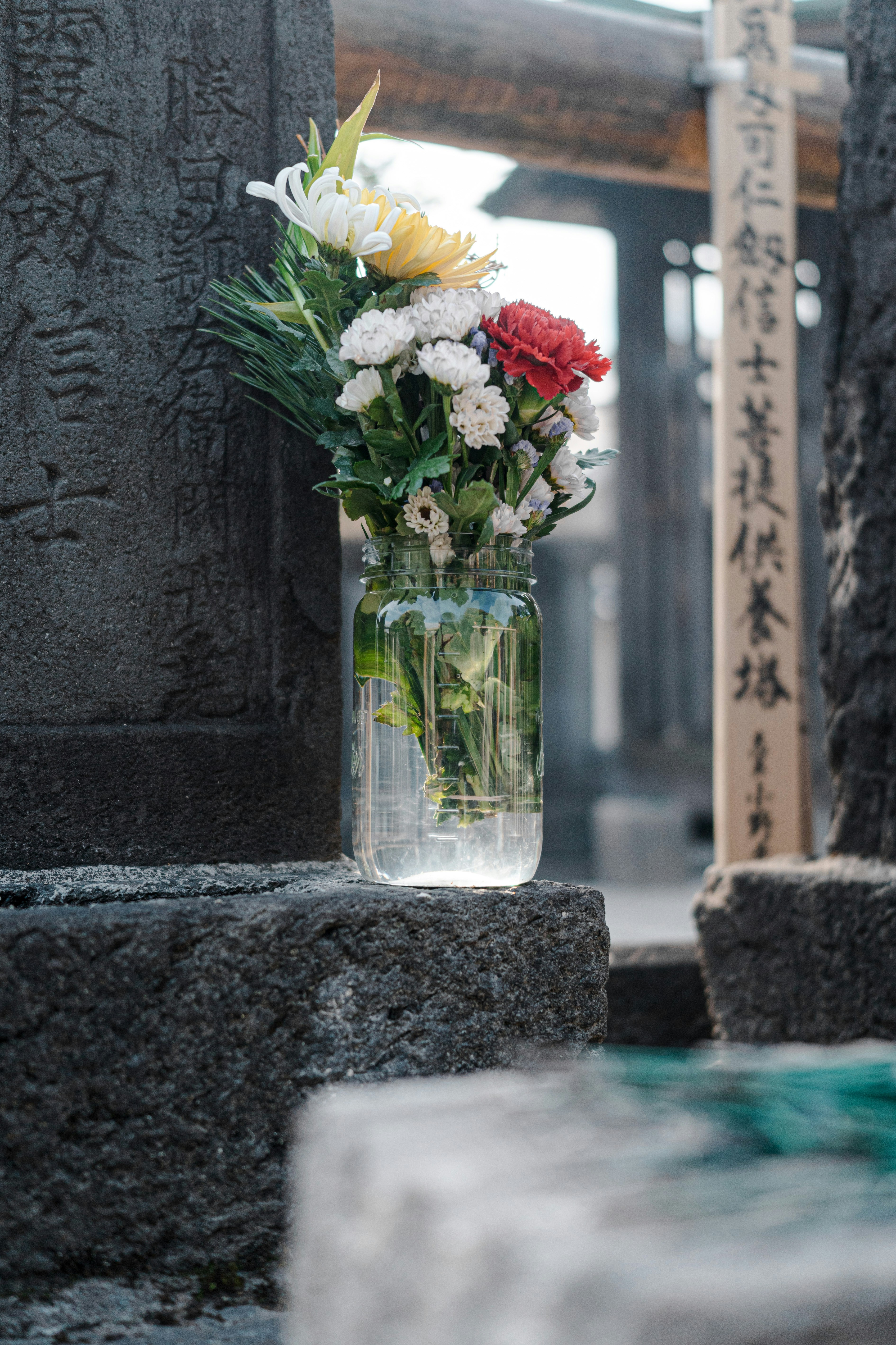 石板の上に座っている花でいっぱいの花瓶
