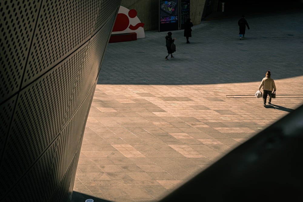 a woman walking down a sidewalk next to a tall building