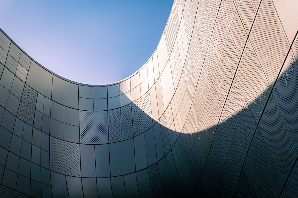 a curved building with a blue sky in the background