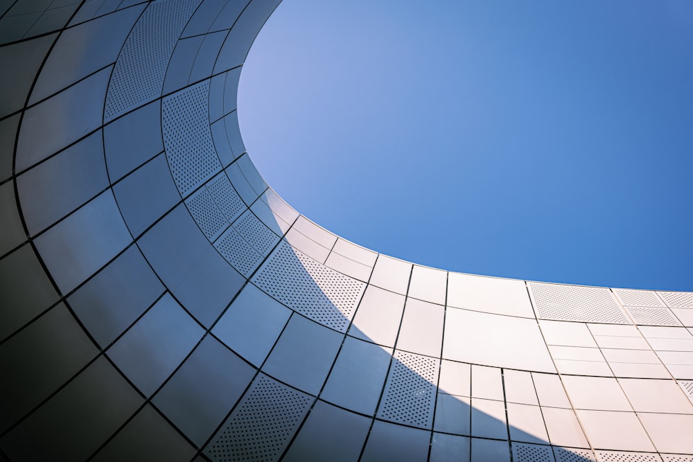 a curved building with a blue sky in the background