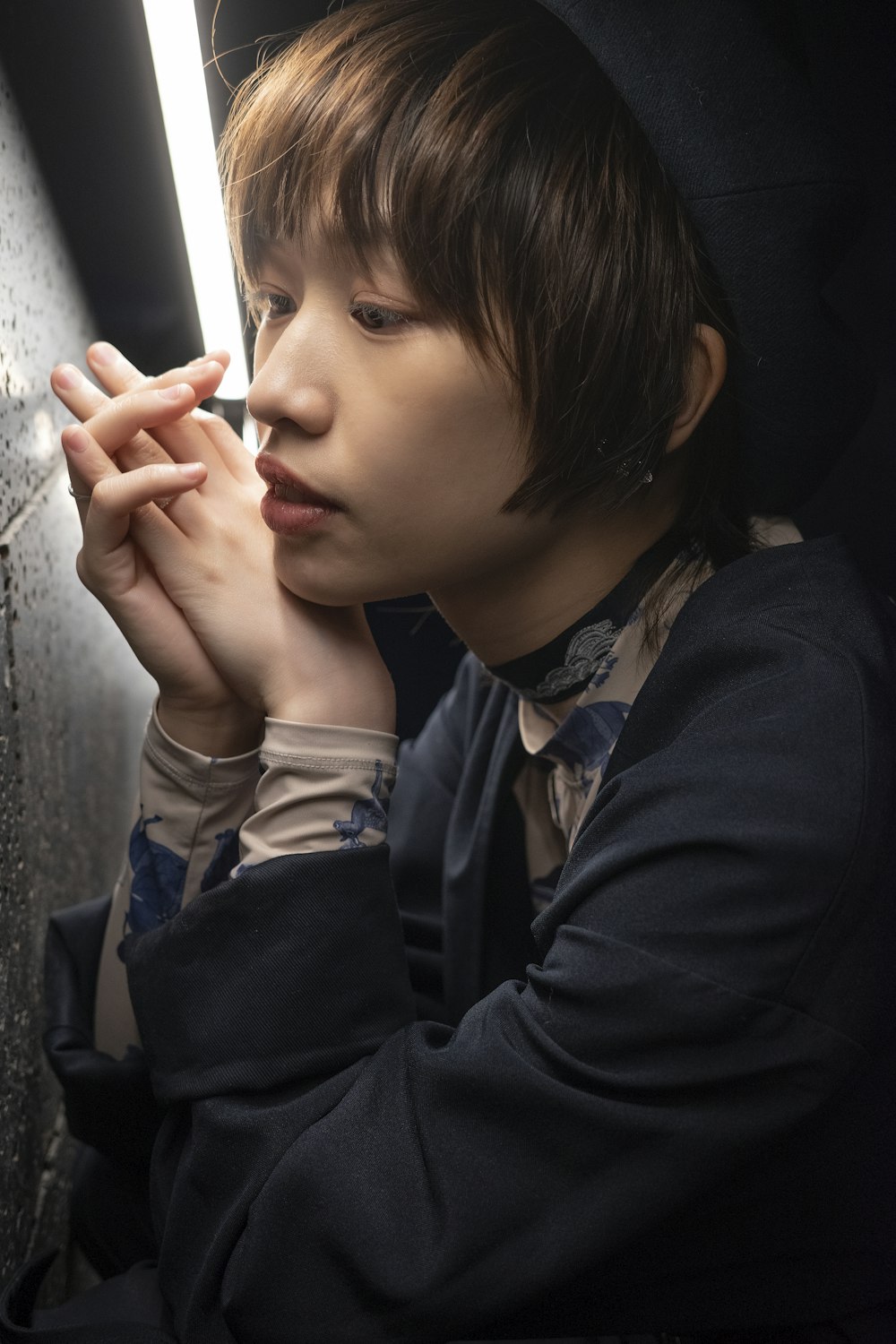 a young man is smoking a cigarette in a dark room