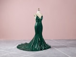 An elegant evening dress with subtle shimmer, displayed on a mannequin in soft, warm lighting.