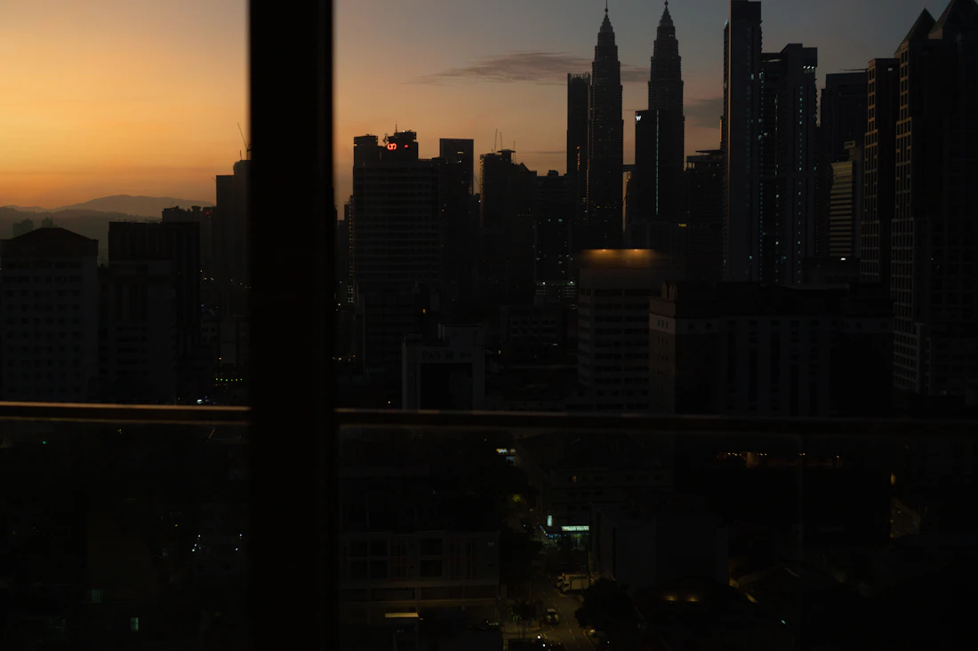 Kuala Lumpur skyline through a window at dusk