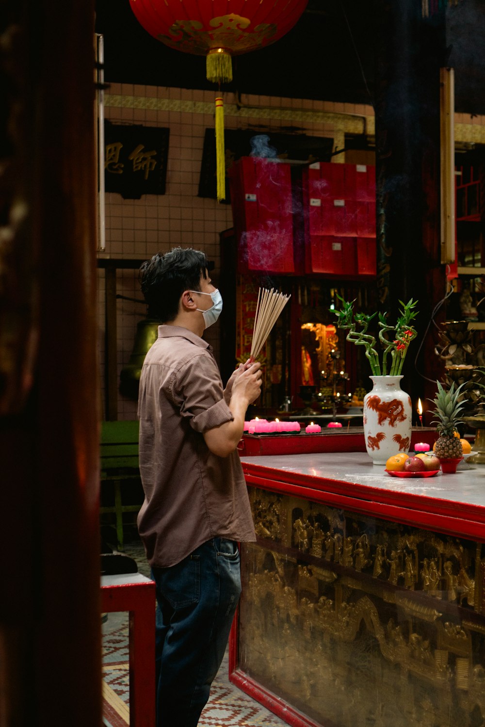 a man standing in front of a table with a vase on it