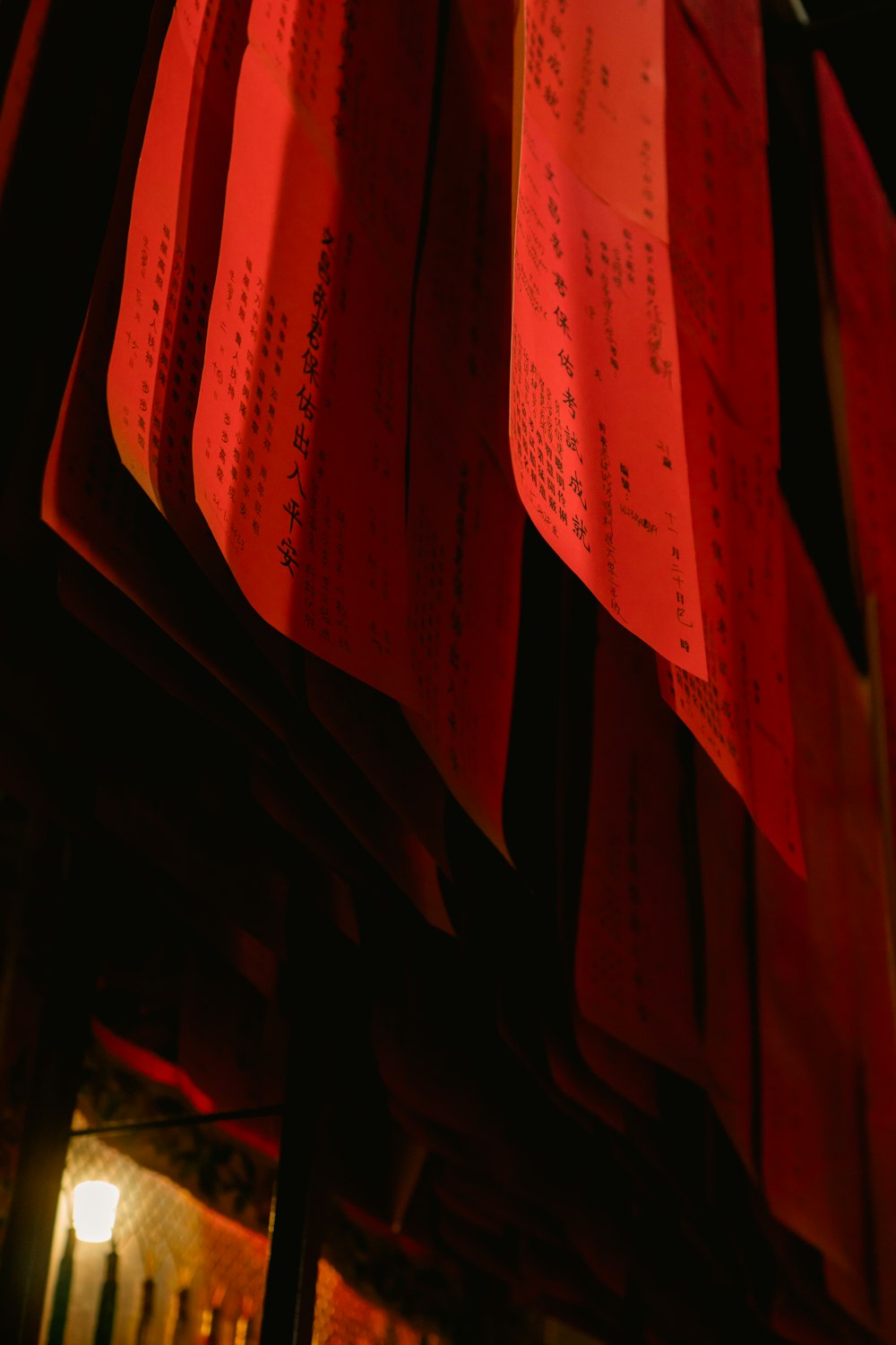 a bunch of red paper hanging from a ceiling