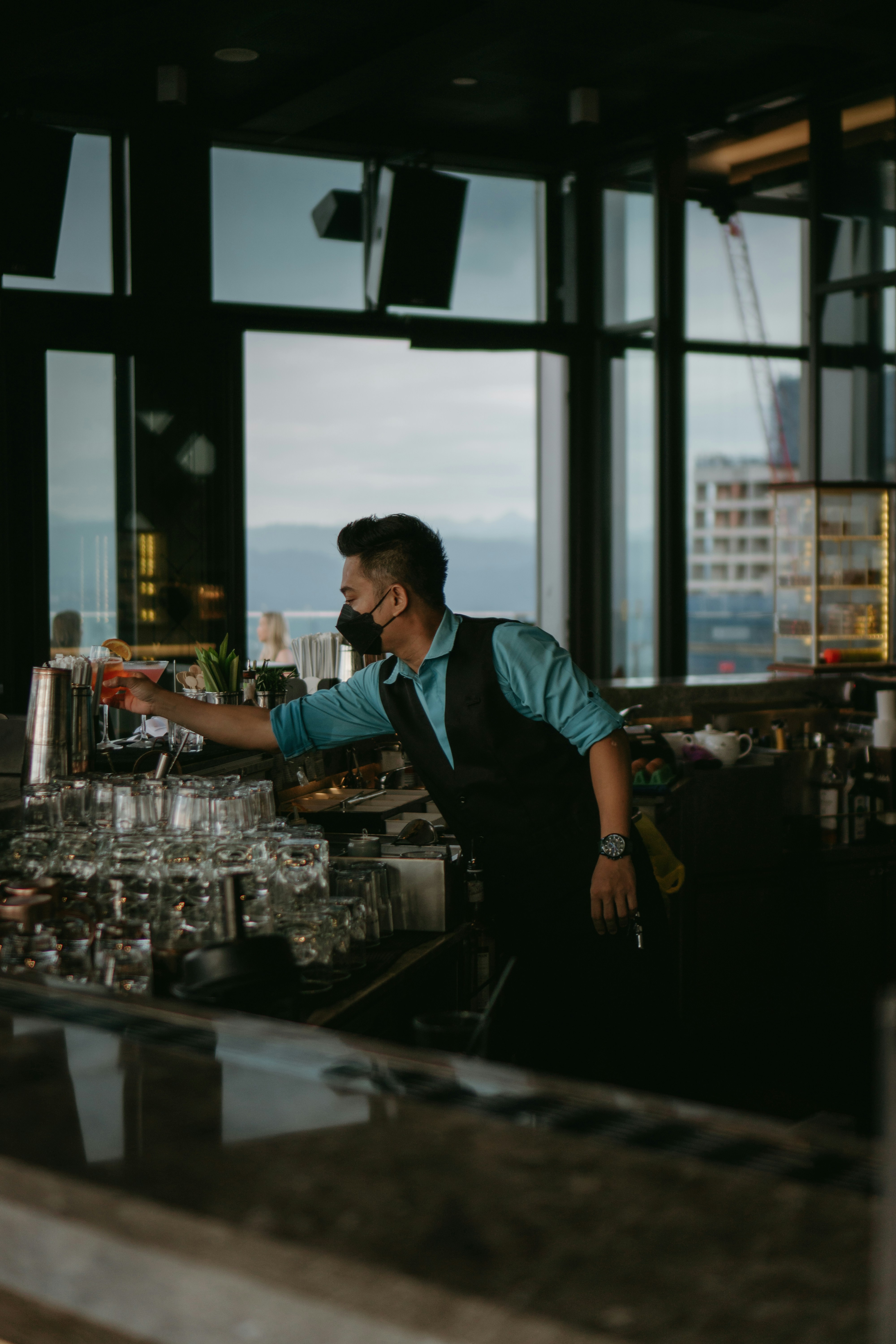 a man standing at a bar pouring a drink