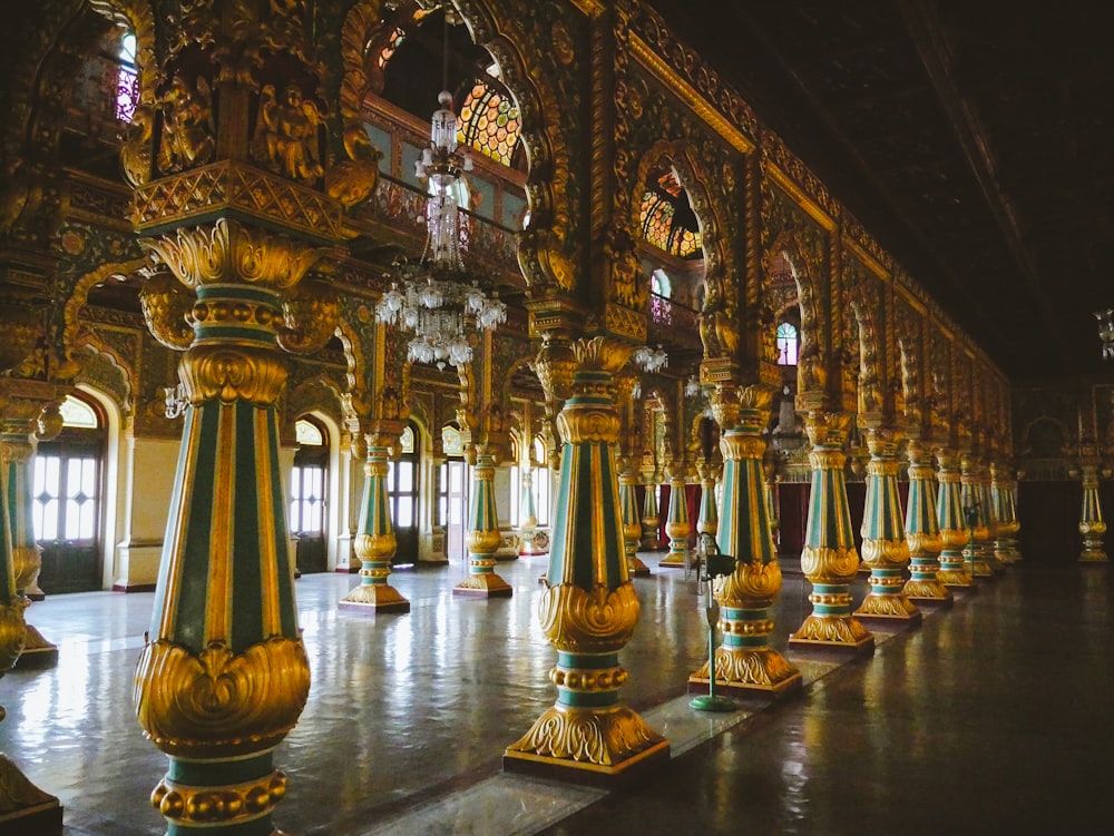 a large room with gold and green columns