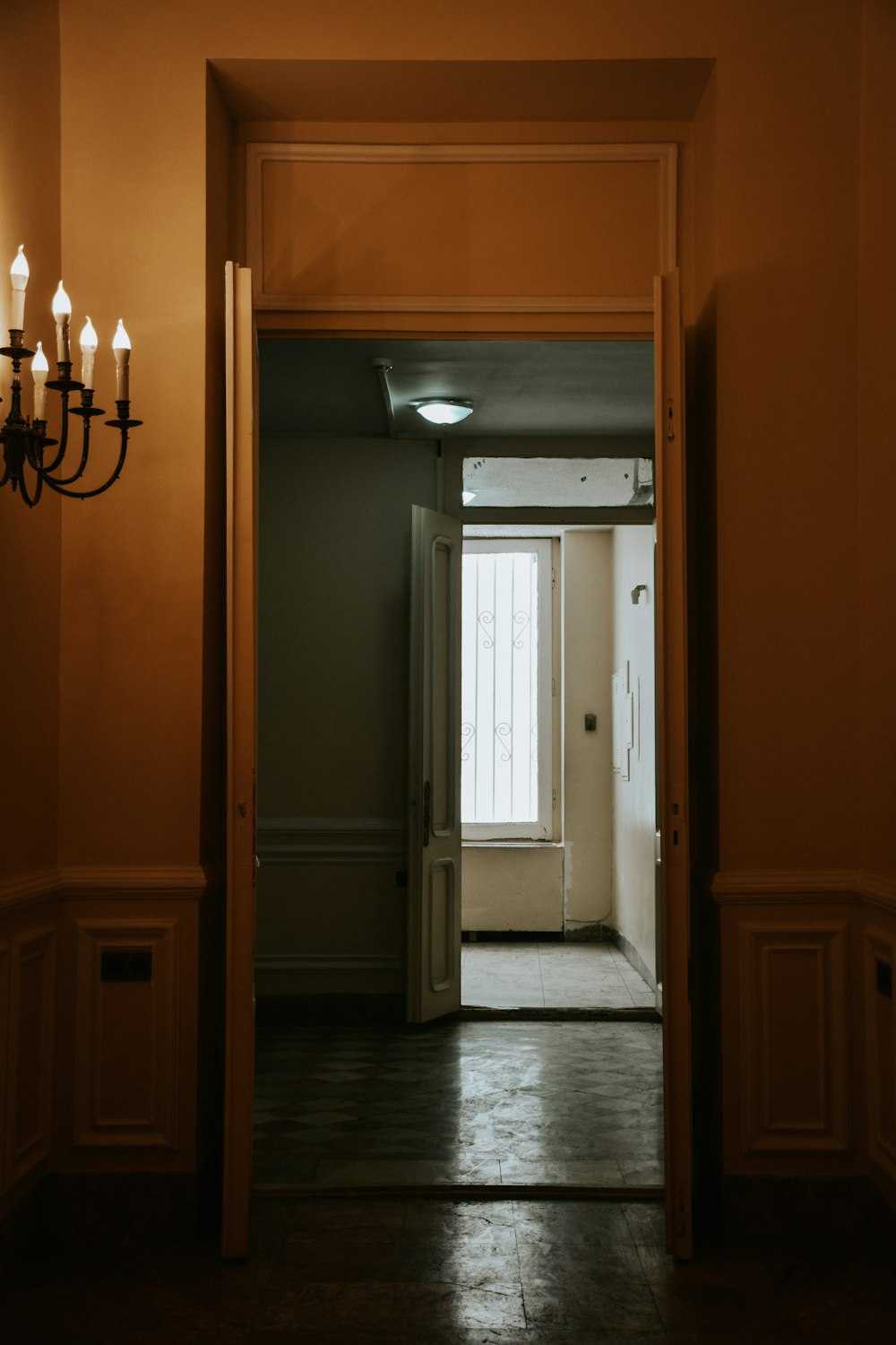 a hallway with a chandelier and a door
