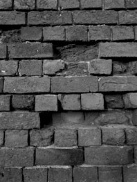 a black and white photo of a brick wall