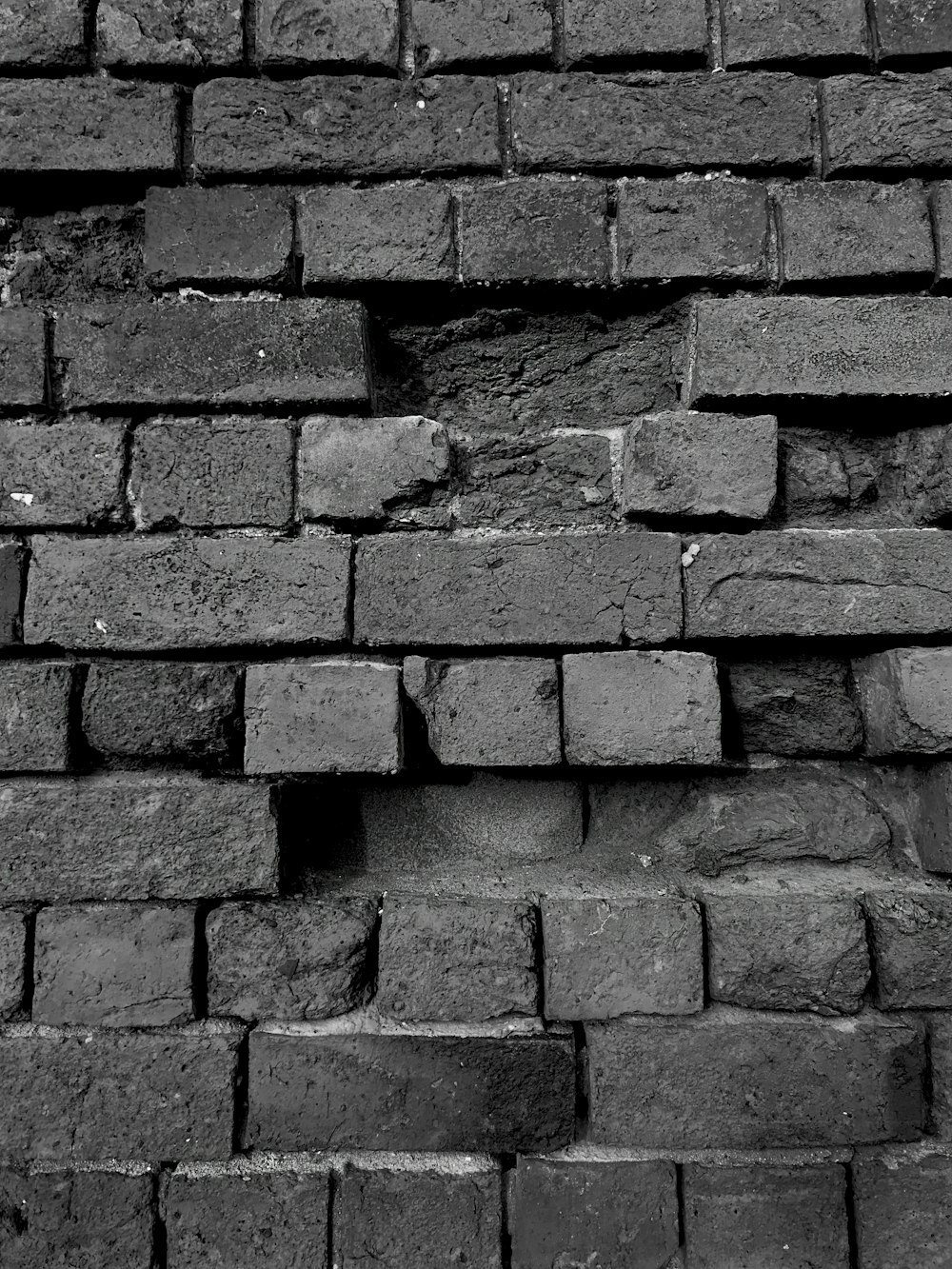 a black and white photo of a brick wall