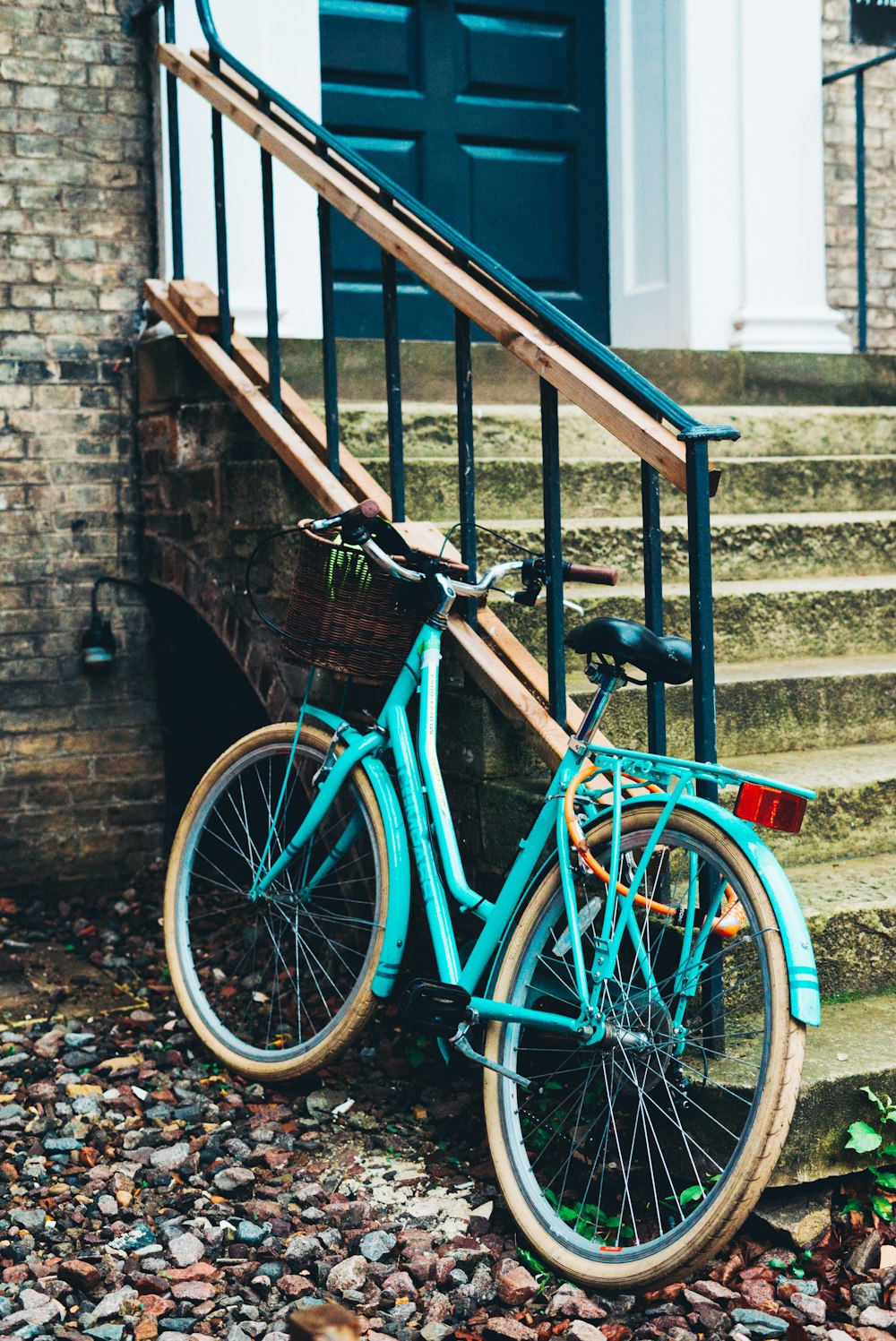 a blue bicycle parked next to a set of stairs
