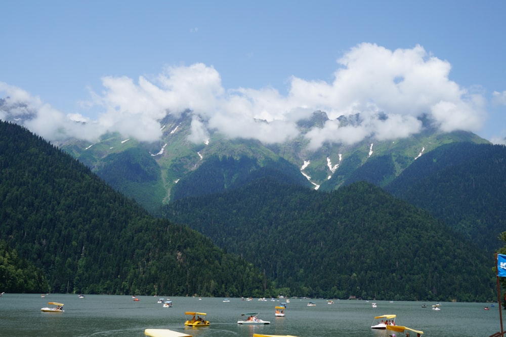 a group of boats floating on top of a lake surrounded by mountains