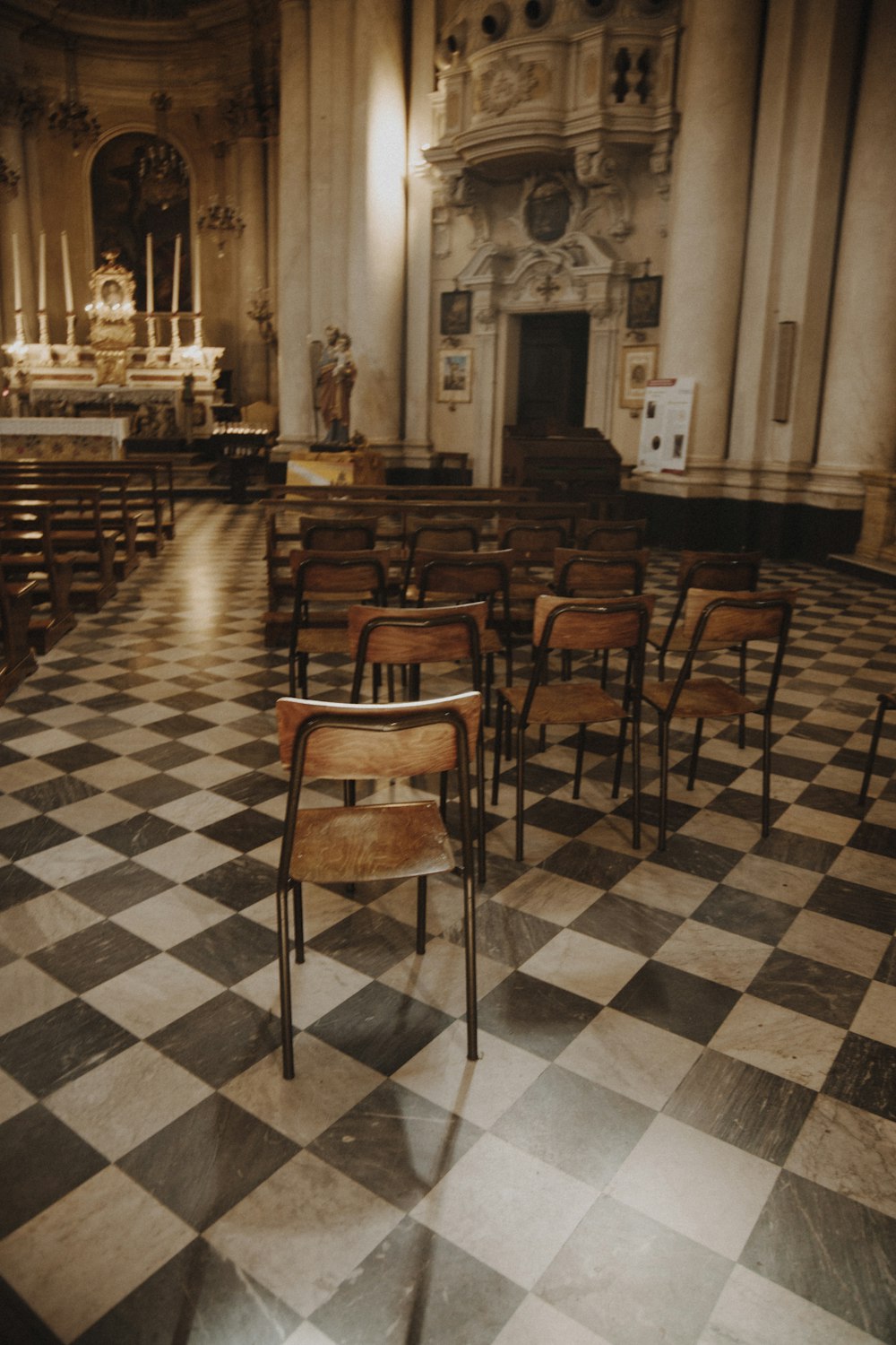 Una iglesia con un piso a cuadros y filas de sillas