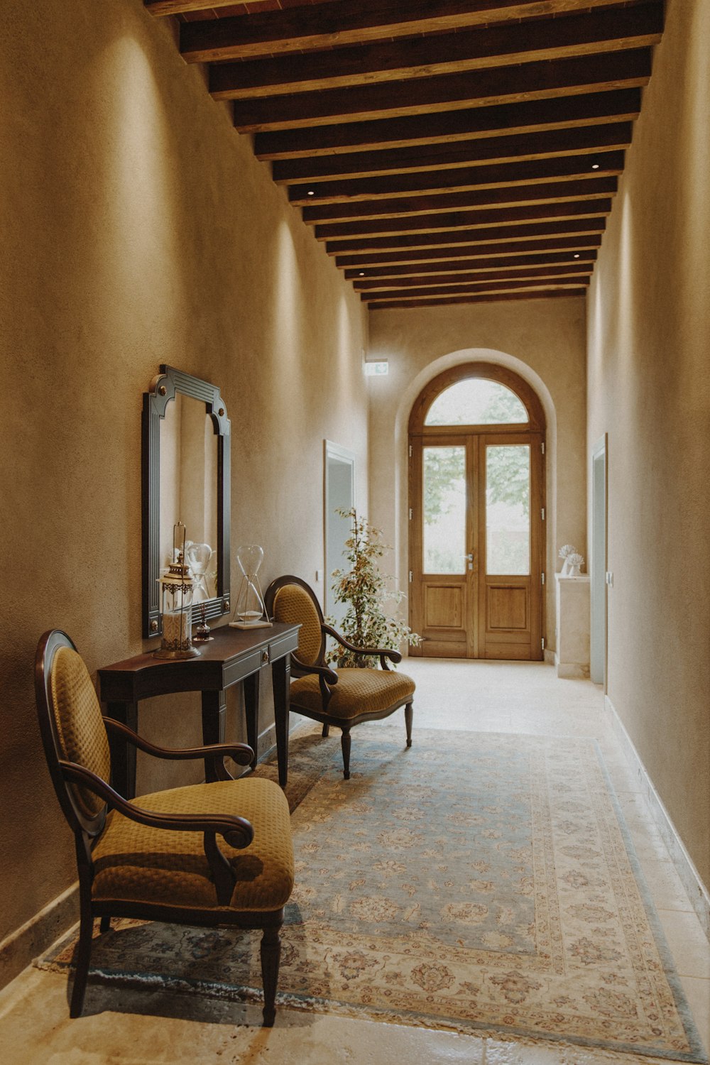 a hallway with a table and chairs and a mirror