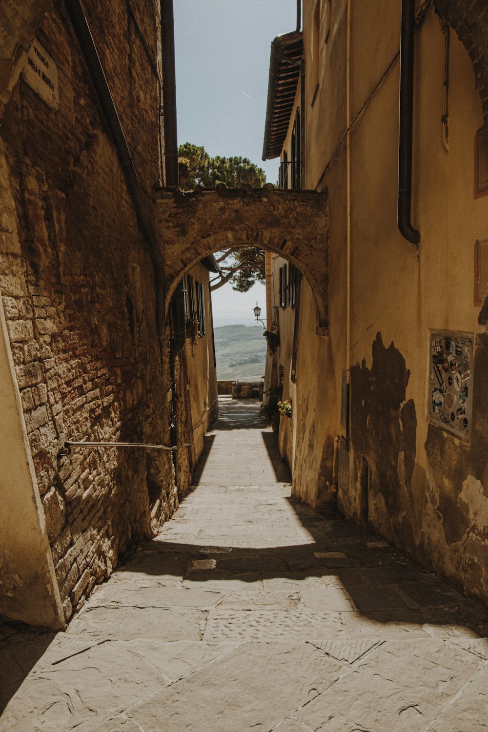 a narrow alley way with a clock on the wall