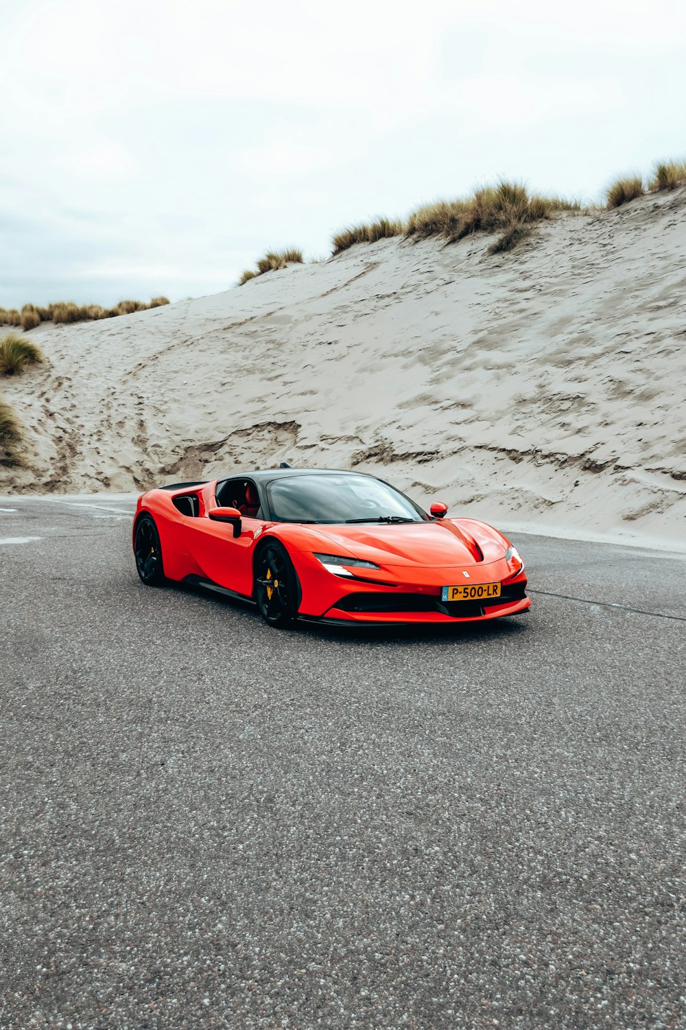 a red sports car driving down a road