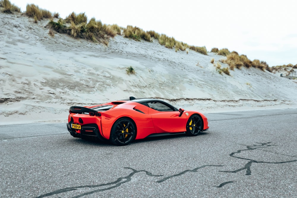 a red sports car driving down a road