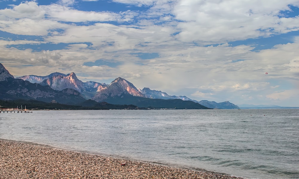 a large body of water with mountains in the background