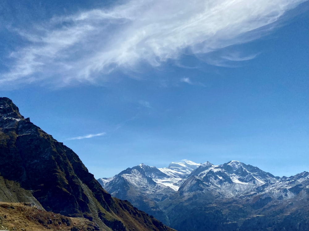 a mountain range with snow capped mountains in the background