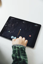 A user happily playing a game on a tablet with the Game Galaxy app open.