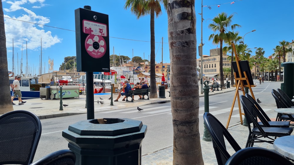 Una strada della città con palme e persone che camminano